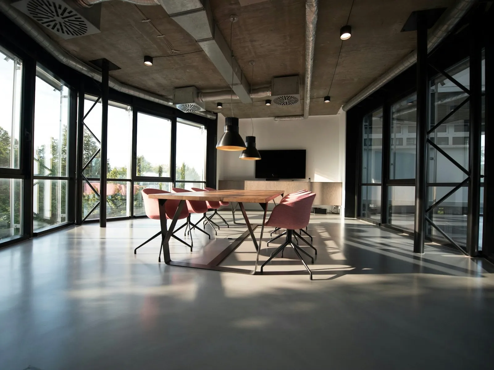 Open workplace with glass partitions and long shared table
