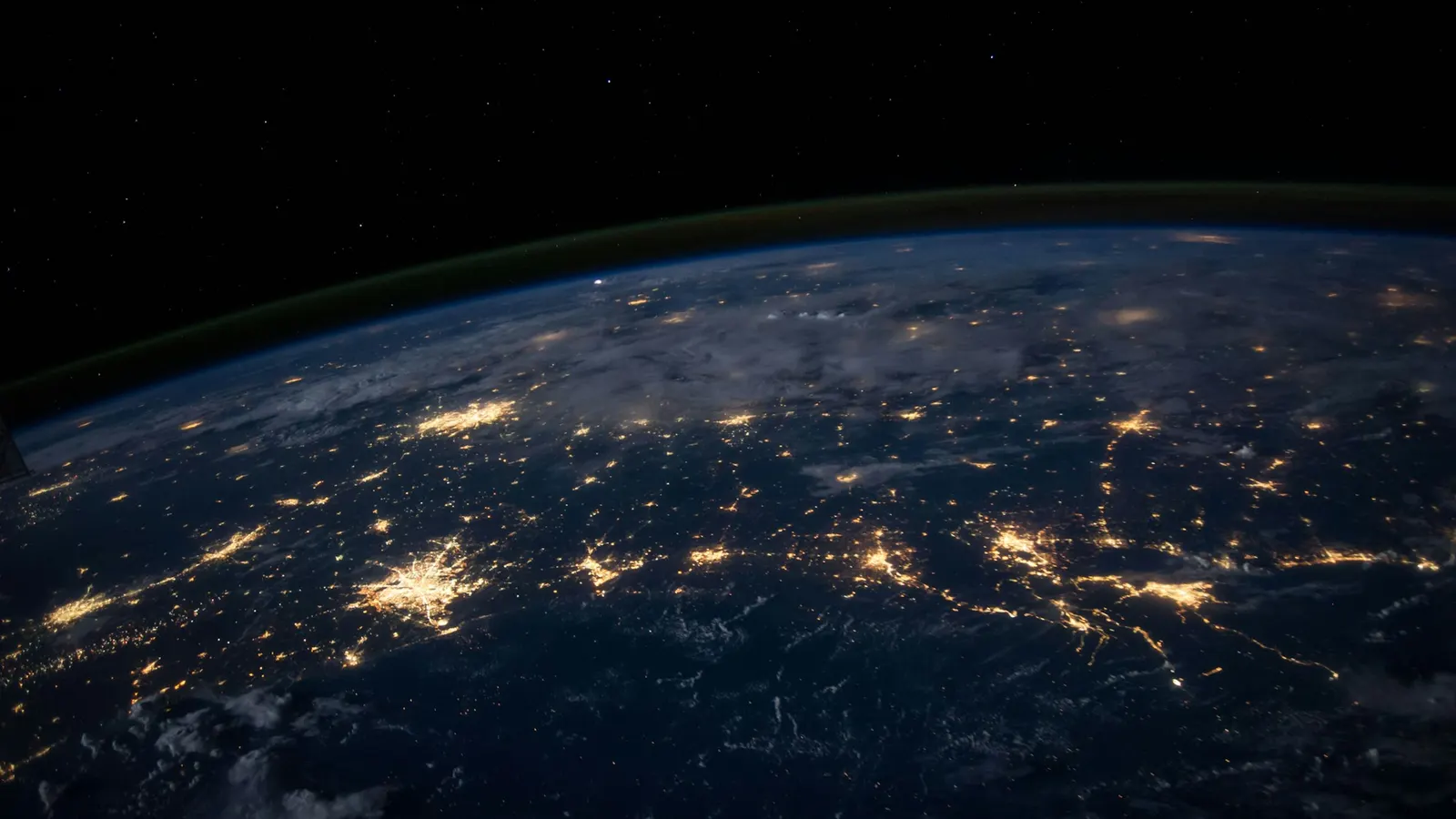 The Earth at night seen from space, with city lights forming a network