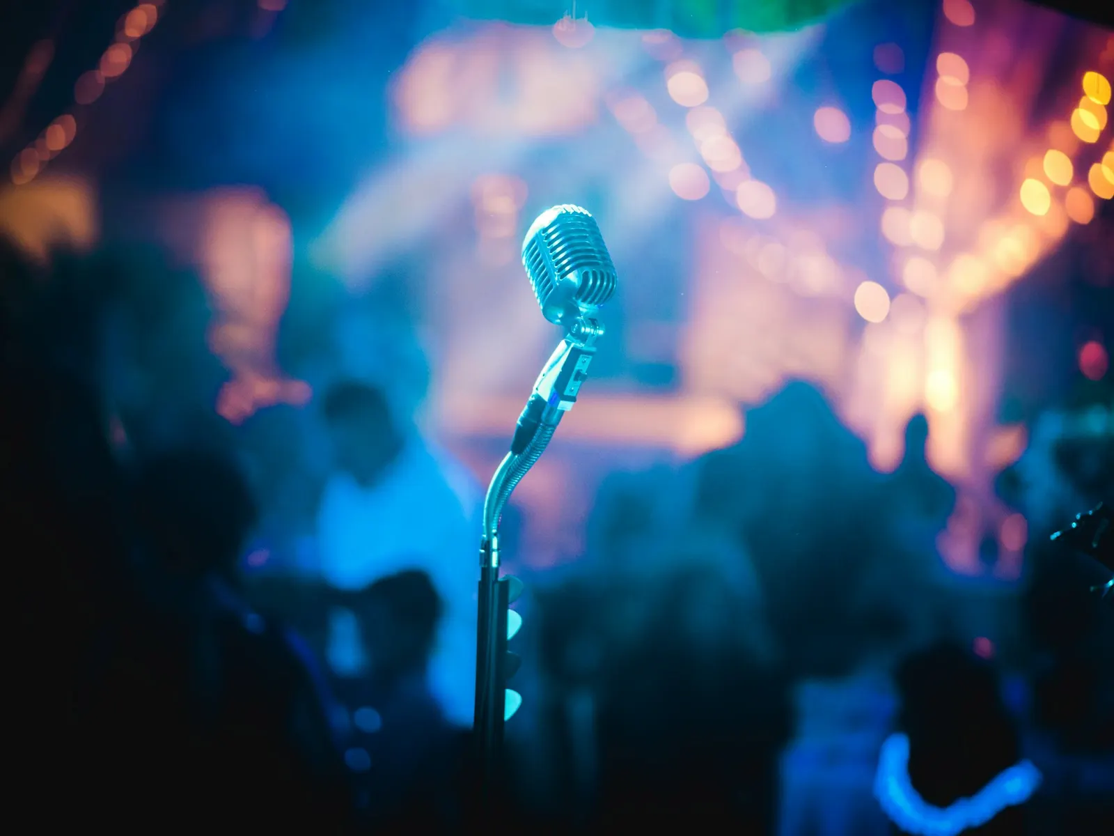 A microphone on a dark stage under blue light