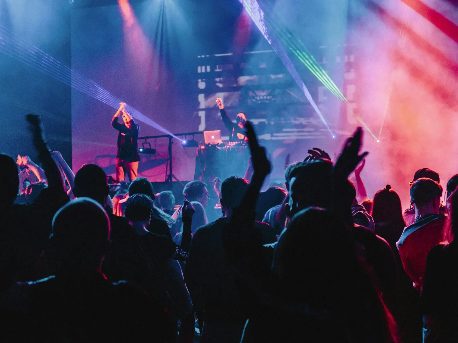 A singer on a small stage under pink and blue light