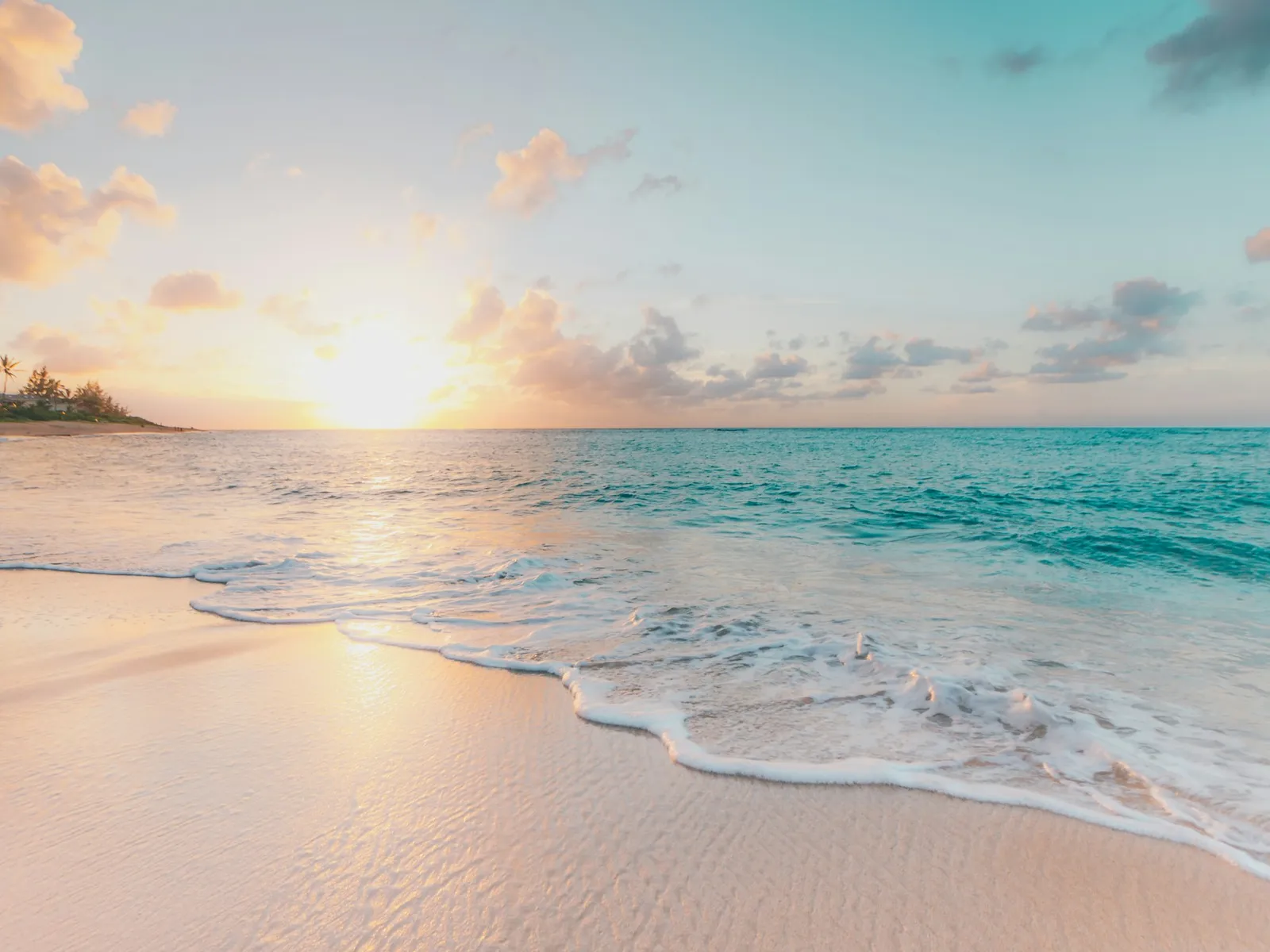 Wide beach with gentle waves and a clear sky